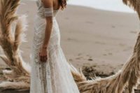 a boho lace strapless wedding dress with a train and arm straps for a boho feel