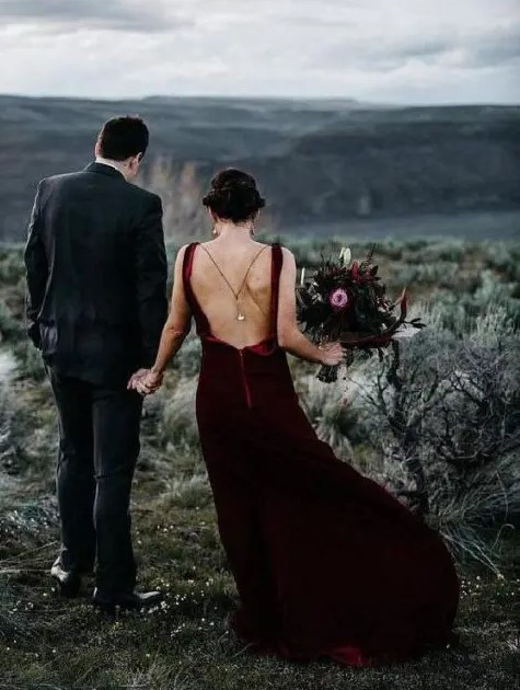 a burgundy velvet wedding dress with a train and a cutout back plus thin straps, a back necklace for a statement