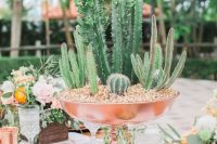 a catchy centerpiece of a copper bowl with lots of cacti growing in it is amazing and bold