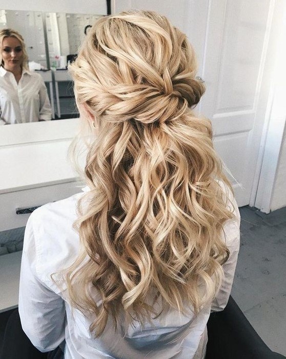 a chic wedding hairstyle with a twisted voluminous top, twisted braids and waves down is great for long hair