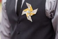 a colorful paper fan wedding boutonniere with a button is a cool and bold idea for rocking in summer