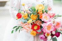 a colorful spring or summer wedding bouquet with marigold, red and pink blooms plus greenery