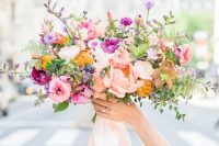 a colorful wedding bouquet with hot pink, blush, mustard and lilac blooms with blush ribbons