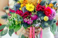 a colorful wedding bouquet with thistles, fuchsia and pink blooms, yellow ones and billy balls plus eucalyptus
