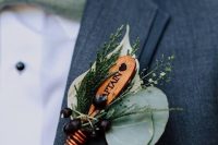 a cool wedding boutonniere of berries, greenery, an oar is a lovely idea for those who like such sport or for a lake