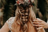 a cool wedding half updo with locks down and a large and thick braid, with neutral and red blooms for an accent