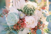 a creative and wild wedding bouquet with lush blooms, red ones, greenery, succulents and cacti is lovely