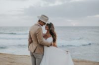 a cute and romantic A-line wedding dress with a lace bodice, a flowy skirt, spaghetti straps for a beach bride