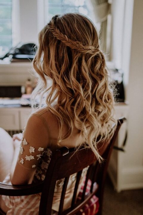 a delicate and lovely boho wedding half updo with a fishtail braid halo and waves down is ideal for a boho bride