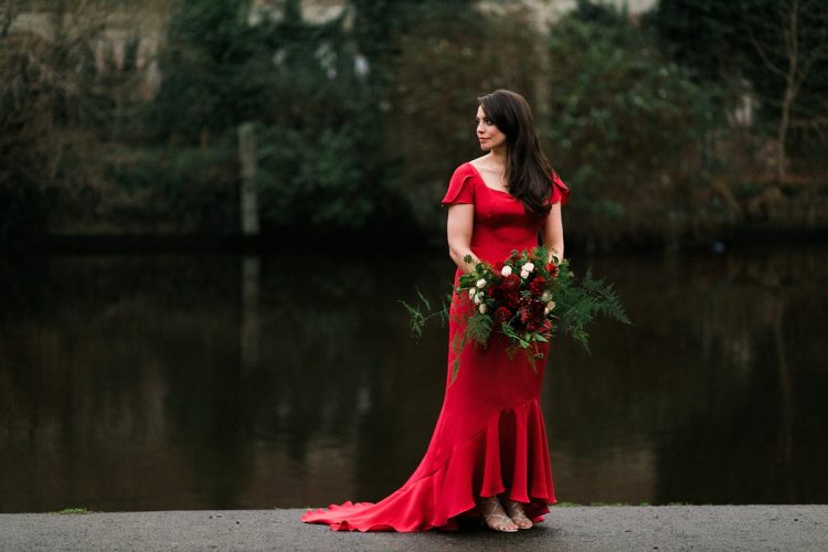 a fantastic A-line red wedding dress with a square neckline, short sleeves and a beautiful high low skirt wiht a train plus silver shoes for a bold fall wedding