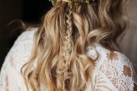 a fantastic summer boho wedding half updo with a large braided halo and more braids and waves down plus a bold flower crown