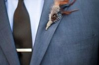 a feather wedding boutonniere wiht a twine wrap will give a slight boho touch to your groom’s look