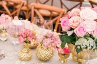 a glam wedding tablescape with gold vases and a bowl, a charger and cutlery, pink flowers and greenery