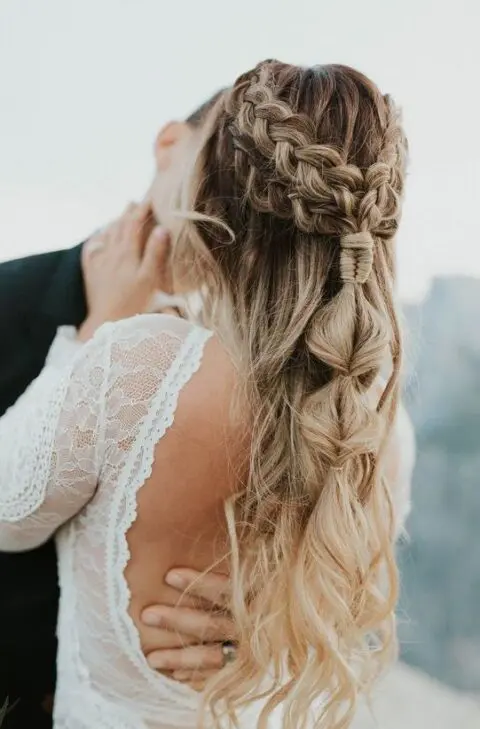 a gorgeous boho wedding half updo with a double braided halo, a bubble ponytail and waves down is amazing