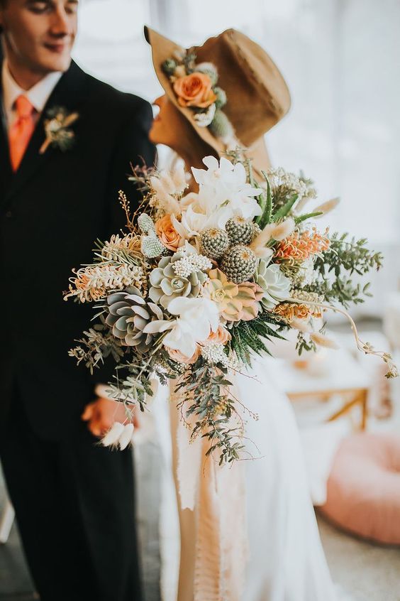 a gorgeous desert wedding bouquet of succulents, cacti, white and orange blooms and greenery