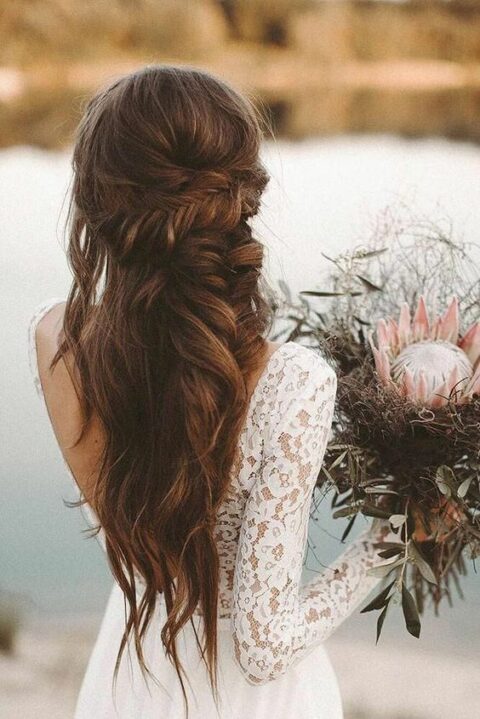 a gorgeous wedding half updo with a messy fishtail braid and an additional twisted one plus textural hair down