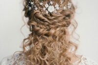 a gorgeous wedding half updo with natural curls – with twists accented with a floral hair piece and curls down