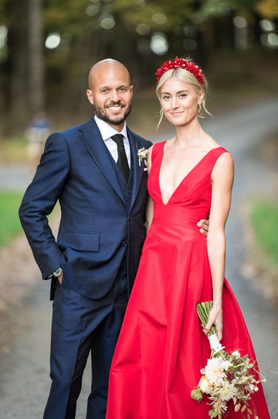 a hot red A line wedding dress with thick straps, a depe neckline and a red floral headpiece for a bold modern wedding with a refined touch