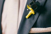 a little camera wedding boutonniere with a yellow bow is a lovely idea for a groom who is a photographer or just loves taking pics