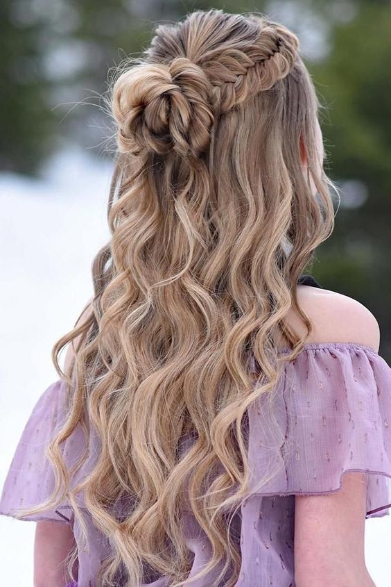 a lovely boho wedding hairstyle with a fishtail braid halo, a large knot and waves down is amazing