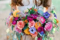a lush colorful bouquet in pink, yellow, purple and fuchsia plus eucalyptus