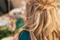 a messy twisted wavy half updo on long hair is a great relaxed idea for a boho bride