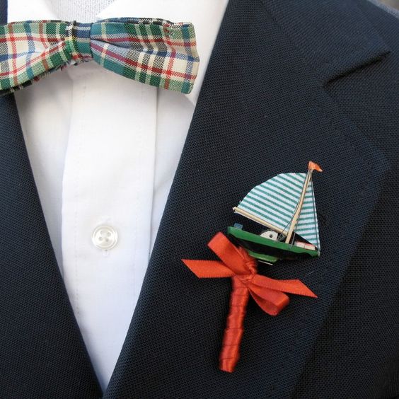 a mini boat with a red bow wedding boutonniere is a lovely idea for those who are tying the knot on the coast