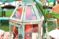 a patina and glass lantern with peaches inside is a marvelous idea of a southern wedding centerpiece