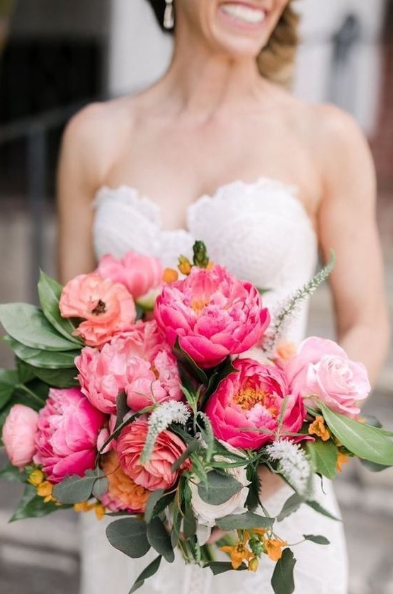 a pretty wedding bouquet with pink, yellow and hot pink flowers and greenery for a spring or summer wedding