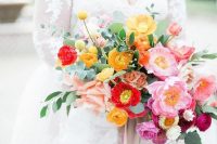 a refined and chic colorful wedding bouquet with yellow, red, pink and hot pink blooms, greenery and long neutral ribbons