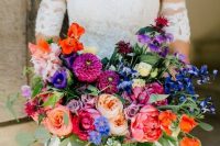 a refined wedding bouquet with pink, red, fuchsia, purple and blue blooms and foliage is a lovely idea for a colorful wedding