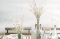 a seaside wedding centerpiece with driftwood, air plants, dried herbs, sea glass and fishing net
