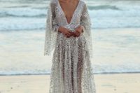 a sparkling silver A-line dress with a plunging neckline and bell sleeves that is inspired by fish scales