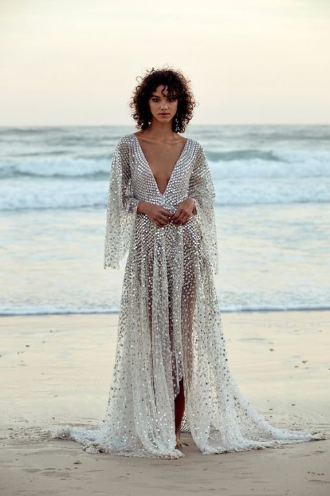 a sparkling silver A-line dress with a plunging neckline and bell sleeves that is inspired by fish scales