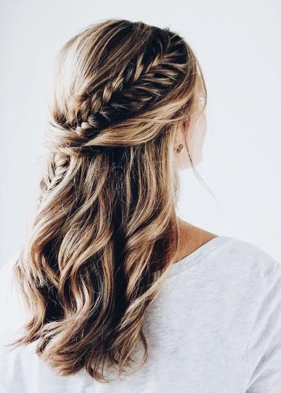 a twisted and braided half updo with messy beachy waves for a boho or free-spirited bride