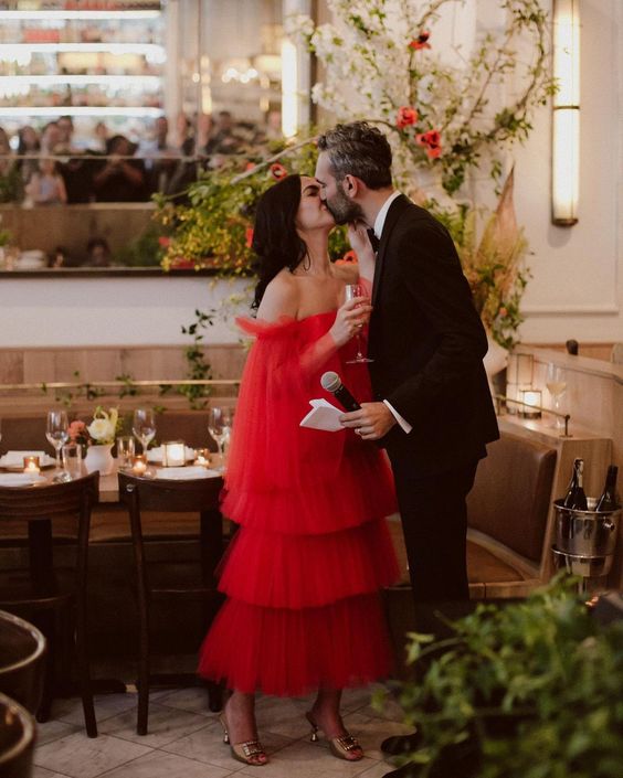 a unique off the shoulder red tea-length wedding dress with a tiered skirt and long wide sleeves is a fantastic idea to stand out
