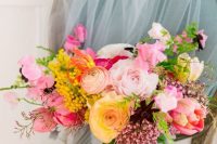 a vibrant wedding bouquet with pink, yellow, blush blooms, deep purple ones and yellow ones plus some greenery