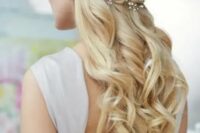 a vintage wedding half updo on very long hair, with a simple top, twists and waves down plus a floral headpiece