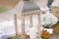 a vintage wooden candle lantern with magnolia leaves and lots of candles inside
