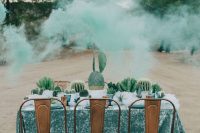 a wedding table runner composed of potted cacti and succulents is a lovely eco-friendly idea for a desert wedding