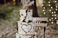 a white bark wedding cake decorated with white blooms and a wood carved calligraphy cake topper is a great idea for a woodland wedding