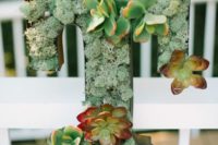 a wood slice, a T letter filled with moss and succulents for a simple rustic centerpiece