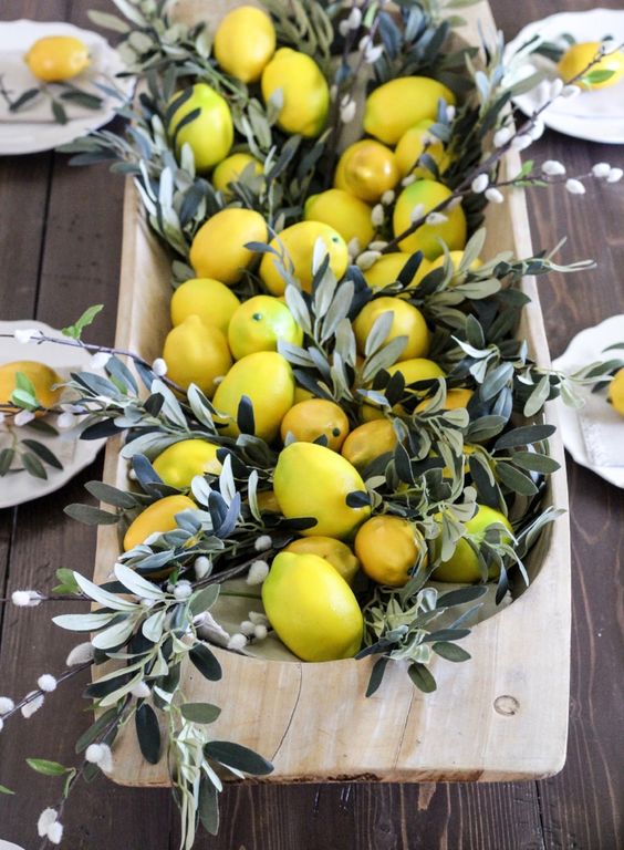 a wooden dough bowl with pussy willow and lemons for a Tuscany-inspired wedding