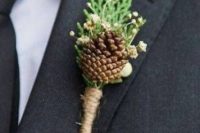a woodland wedding boutonniere of a pinecone, berries, greenery and with a twine wrap is a stylish idea for a woodland wedding in any season