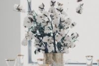 cotton branches in a copper vase are a cool centerpiece idea that you may rock at a winter wedding
