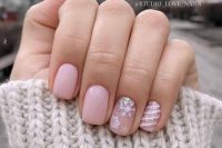 light pink wedding nails accented with snowflakes and stripes and glitter are adorable for a winter wedding