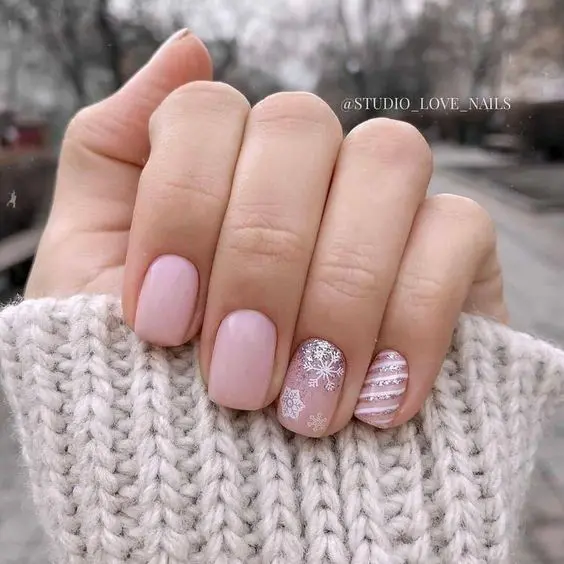light pink wedding nails accented with snowflakes and stripes and glitter are adorable for a winter wedding