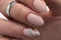 matte blush nails with a silver leaf sticker for an accent is a beautiful take on usual nude nails, with texture and interest