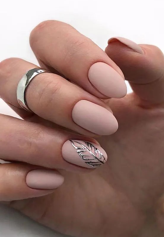 matte blush nails with a silver leaf sticker for an accent is a beautiful take on usual nude nails, with texture and interest