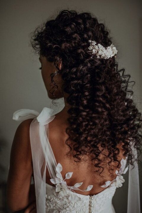 naturally curly hair with twists on top secured with a beautiful embellished hair piece and curls down looks amazing